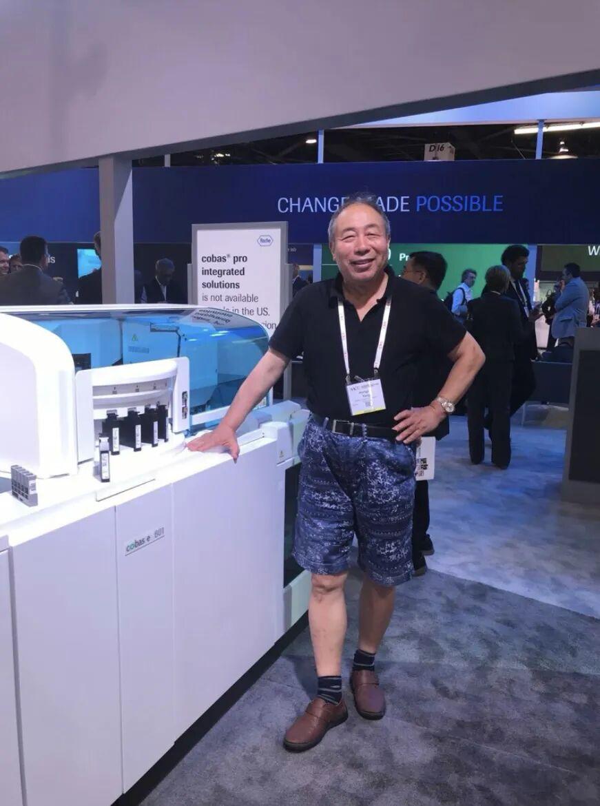 2018年美国AACC大会，Roche展销人员邀请杨宏钧在最新仪器模型前留影
